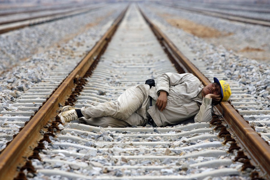 80315-a-worker-naps-on-the-railway-at-the-construction-site-of-wuhan-north-r.jpg